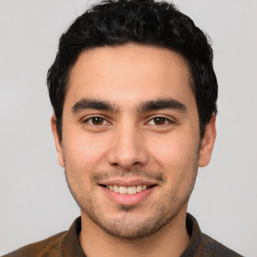 Joyful white young-adult male with short  black hair and brown eyes