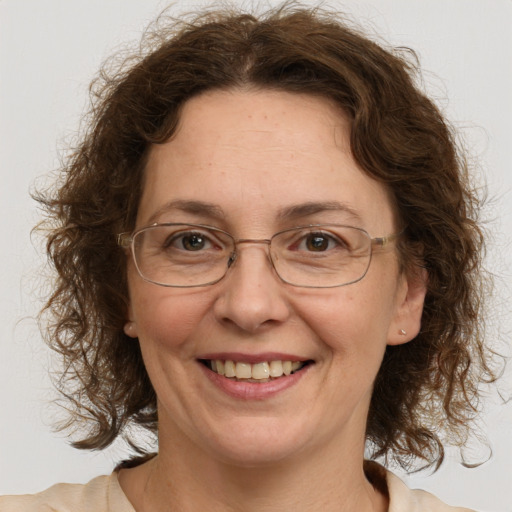 Joyful white adult female with medium  brown hair and green eyes