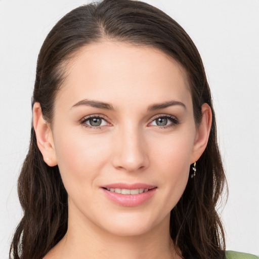 Joyful white young-adult female with long  brown hair and grey eyes