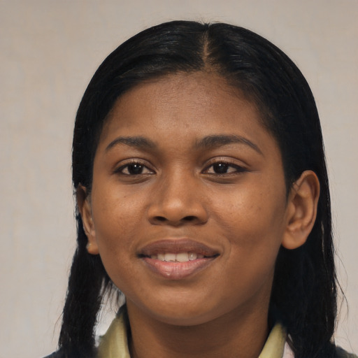 Joyful black young-adult female with long  black hair and brown eyes