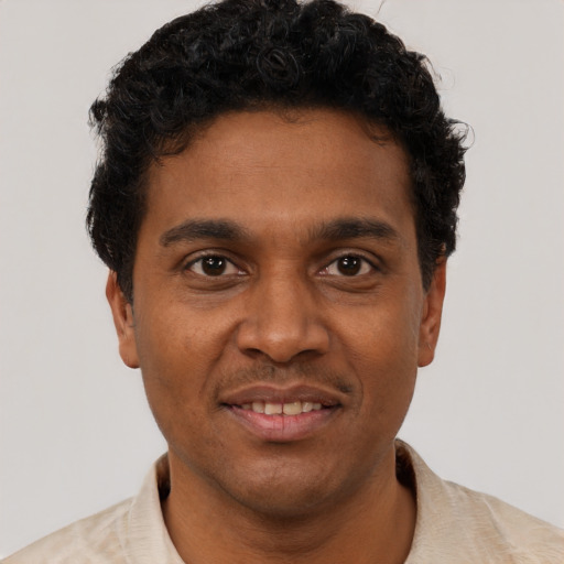Joyful black young-adult male with short  brown hair and brown eyes