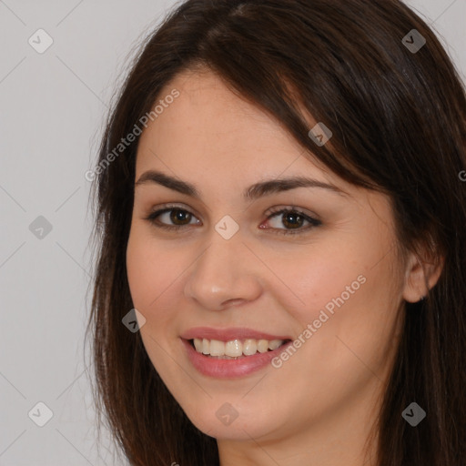 Joyful white young-adult female with long  brown hair and brown eyes