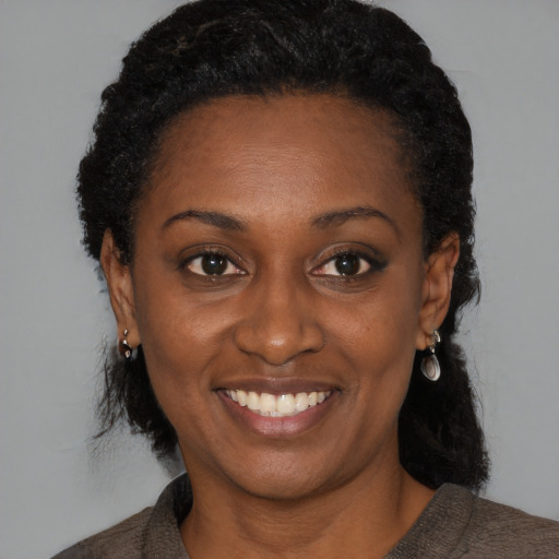 Joyful black young-adult female with medium  black hair and brown eyes