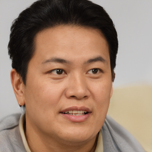 Joyful asian young-adult male with short  brown hair and brown eyes