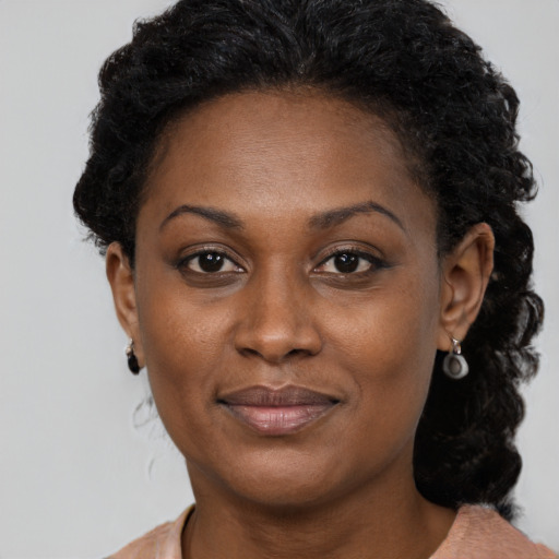 Joyful black adult female with short  brown hair and brown eyes