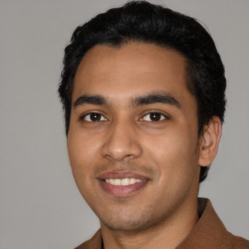 Joyful latino young-adult male with short  black hair and brown eyes