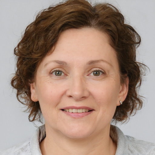 Joyful white adult female with medium  brown hair and blue eyes