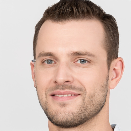 Joyful white young-adult male with short  brown hair and grey eyes