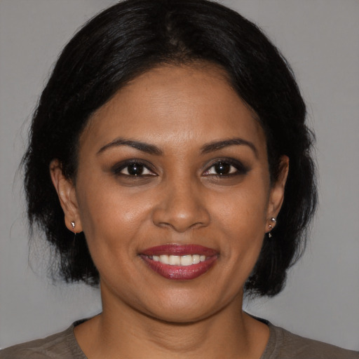 Joyful black young-adult female with medium  brown hair and brown eyes