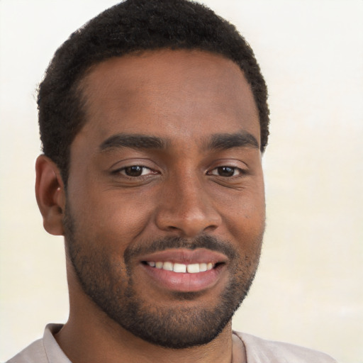 Joyful black young-adult male with short  brown hair and brown eyes