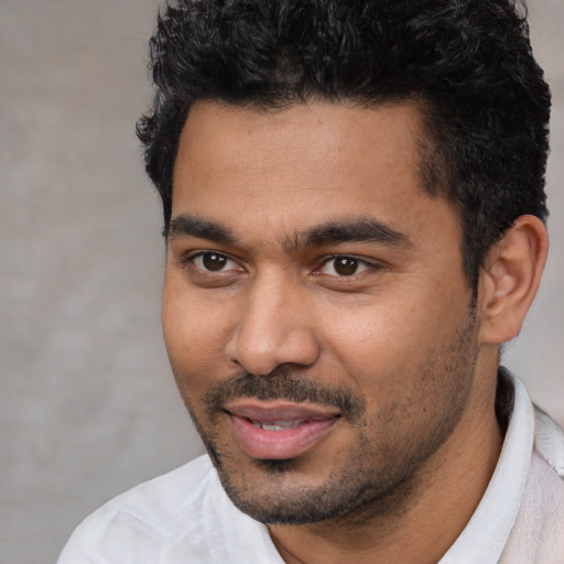 Joyful latino young-adult male with short  black hair and brown eyes