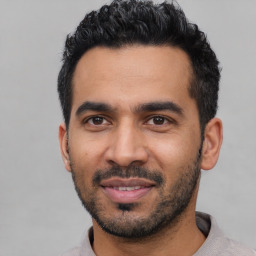 Joyful latino young-adult male with short  black hair and brown eyes