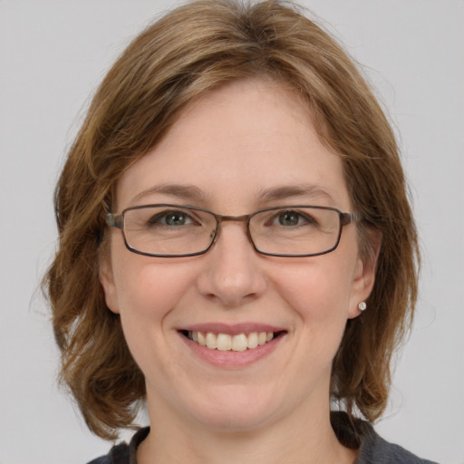 Joyful white adult female with medium  brown hair and blue eyes