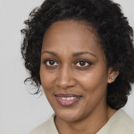 Joyful black adult female with long  brown hair and brown eyes