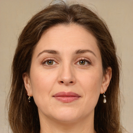 Joyful white adult female with long  brown hair and green eyes