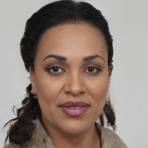 Joyful black adult female with medium  brown hair and brown eyes
