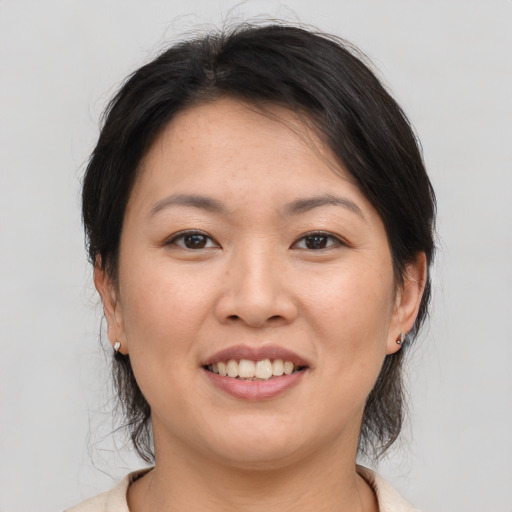 Joyful asian young-adult female with medium  brown hair and brown eyes