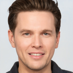 Joyful white young-adult male with short  brown hair and grey eyes