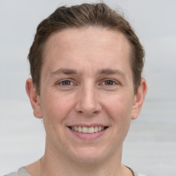 Joyful white adult male with short  brown hair and grey eyes