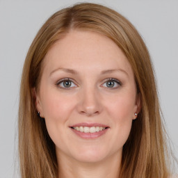 Joyful white young-adult female with long  brown hair and grey eyes