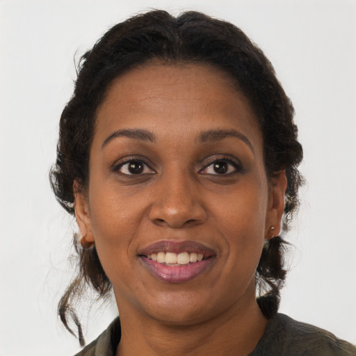 Joyful black adult female with long  brown hair and brown eyes