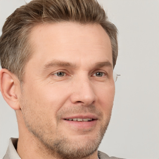 Joyful white adult male with short  brown hair and grey eyes