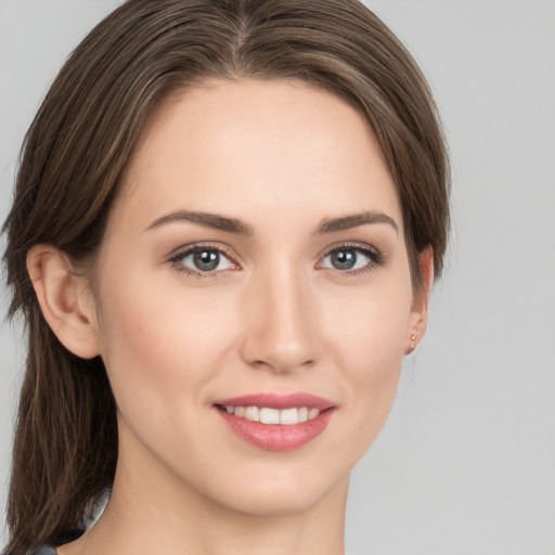 Joyful white young-adult female with medium  brown hair and grey eyes