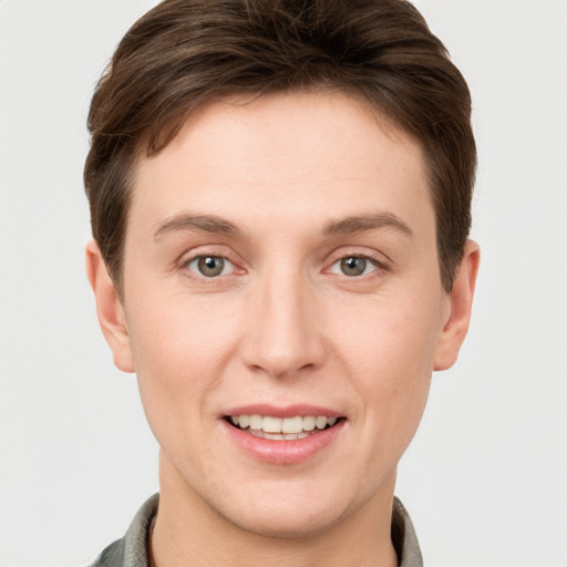 Joyful white young-adult male with short  brown hair and grey eyes