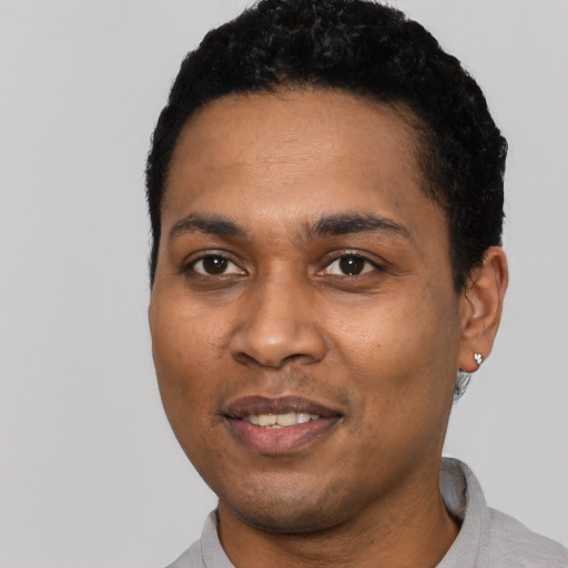 Joyful black young-adult male with short  black hair and brown eyes