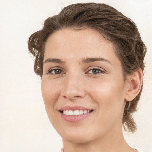 Joyful white young-adult female with medium  brown hair and green eyes