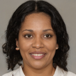 Joyful black adult female with medium  brown hair and brown eyes