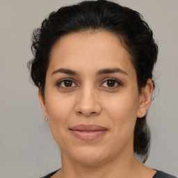 Joyful latino adult female with medium  brown hair and brown eyes