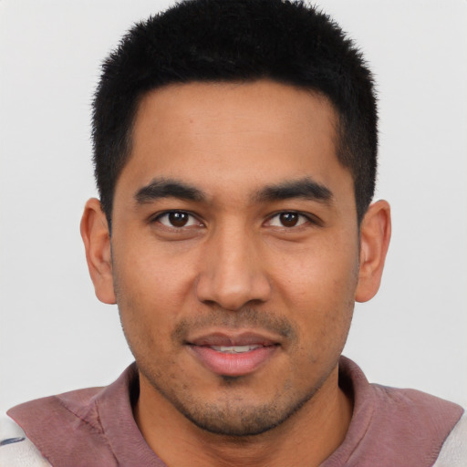 Joyful latino young-adult male with short  black hair and brown eyes