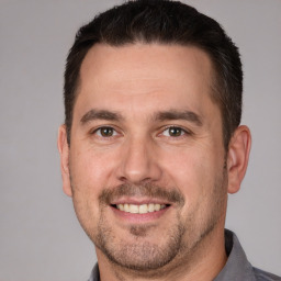 Joyful white adult male with short  brown hair and brown eyes