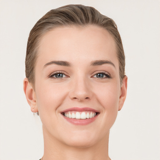 Joyful white young-adult female with short  brown hair and grey eyes