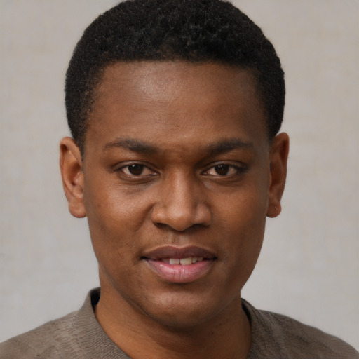 Joyful black young-adult male with short  black hair and brown eyes