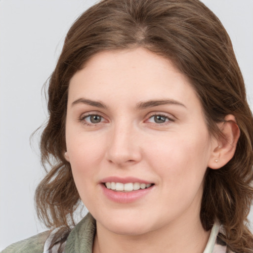 Joyful white young-adult female with medium  brown hair and grey eyes