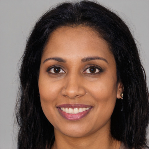 Joyful black young-adult female with long  brown hair and brown eyes