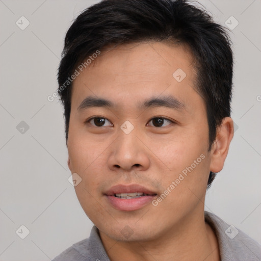 Joyful asian young-adult male with short  black hair and brown eyes