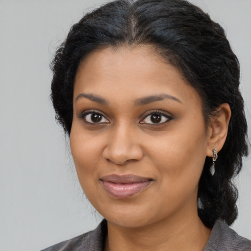 Joyful black young-adult female with medium  brown hair and brown eyes