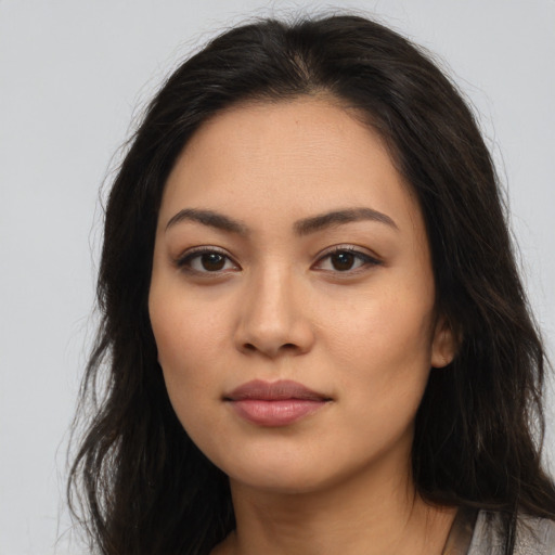 Joyful latino young-adult female with long  brown hair and brown eyes