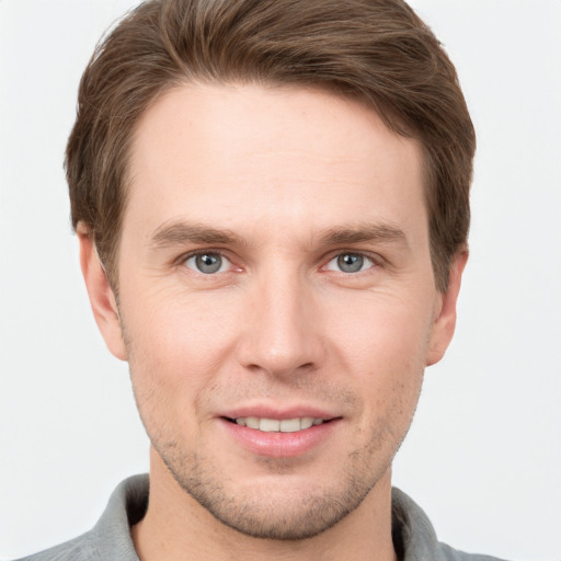 Joyful white young-adult male with short  brown hair and grey eyes