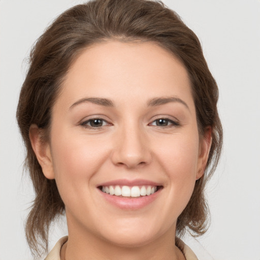 Joyful white young-adult female with medium  brown hair and grey eyes