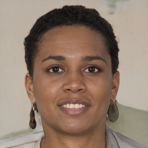 Joyful black young-adult female with short  brown hair and brown eyes