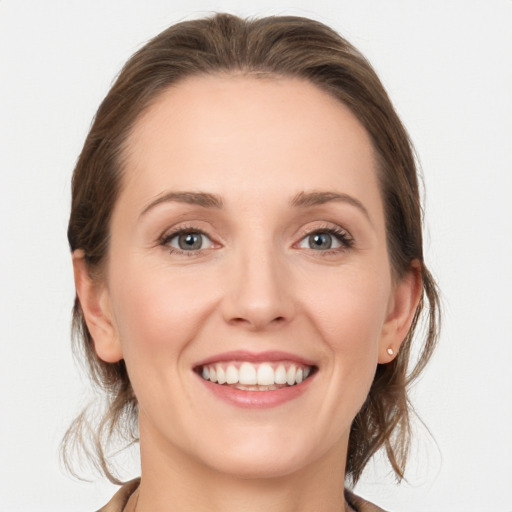 Joyful white young-adult female with medium  brown hair and grey eyes