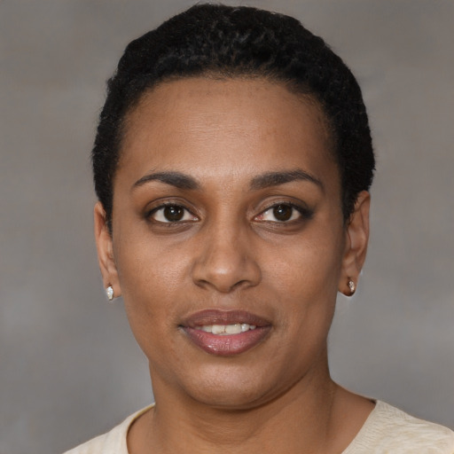 Joyful black young-adult female with short  black hair and brown eyes