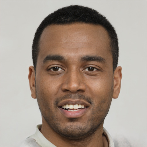 Joyful black young-adult male with short  black hair and brown eyes