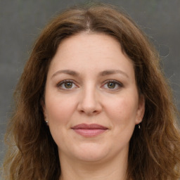 Joyful white adult female with long  brown hair and green eyes