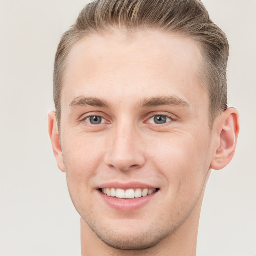 Joyful white young-adult male with short  brown hair and grey eyes