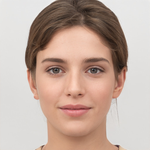 Joyful white young-adult female with short  brown hair and grey eyes